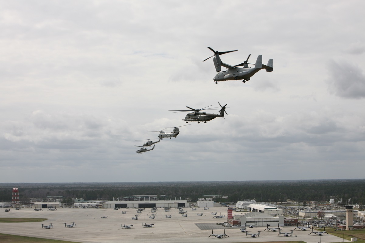U.S. Marine MV-22 Osprey, CH-53 Super Stallion, CH-46 Sea Knight, and AH-1 Cobra helicopters flying in formation over MCAS New River